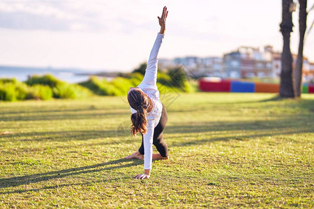 做瑜伽的年轻女运动员教练在公园教侧图片