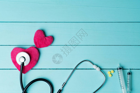 世界心脏健康日概念与蓝色木质背景红心听诊器图片