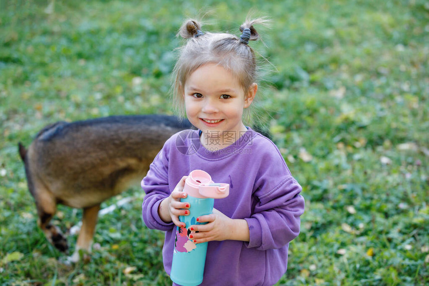 穿紫色西装的小女孩在夏季城市公园图片