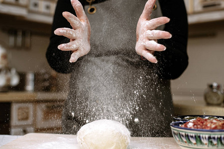 女人在家准备面粉用面粉拍手面粉散布家图片