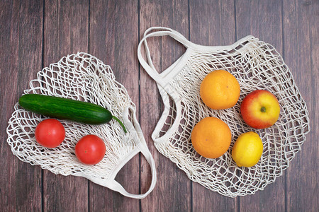 木制背景上可重复使用的环保网袋上的蔬菜和水果停止污染零浪费购物生图片