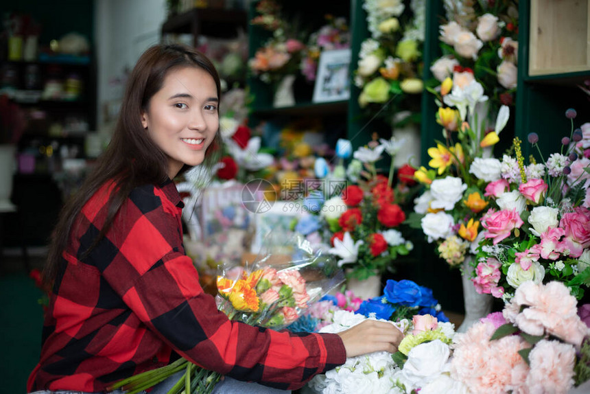 鲜花店老板和年轻花店家在店里检查花图片