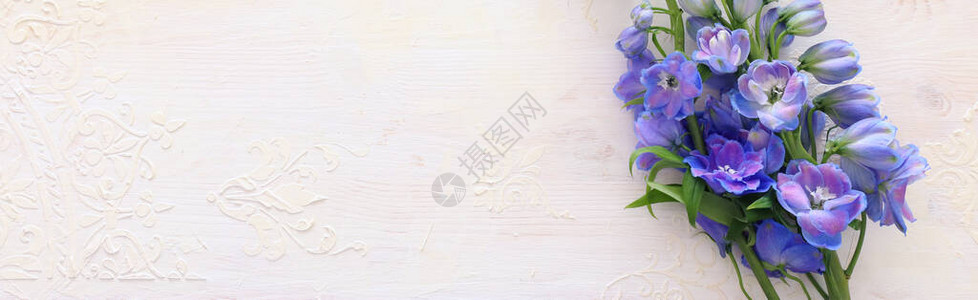 白色复古木质背景上的蓝色花朵春天花束图片