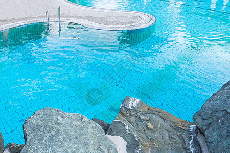 被石头包围的蓝色水池的顶视图夏季放松水疗水上乐园运动图片