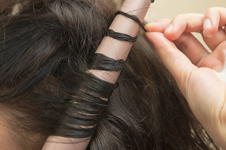 美发师正在做卷发使用陶瓷卷发棒的头发造型年轻女子造型图片