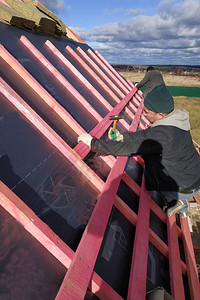 工人用绝缘材料盖住屋顶图片