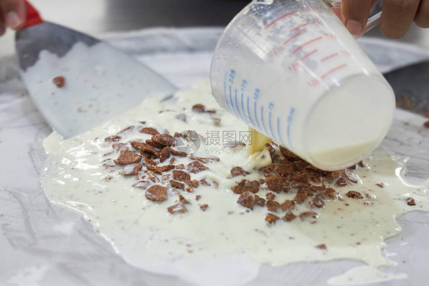 冰淇淋制造器将新鲜牛奶倒到冷冻金属表面图片