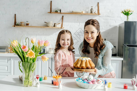 可爱的孩子和有吸引力的母亲在东蛋装饰兔子东方面包图片