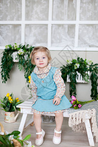 小女孩在长木凳上与春天的花朵图片