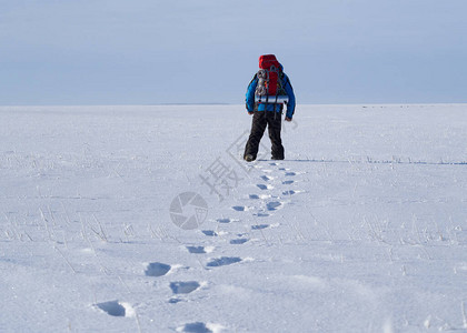 孤单的背包客走着扔雪地度过了艰苦旅行的图片