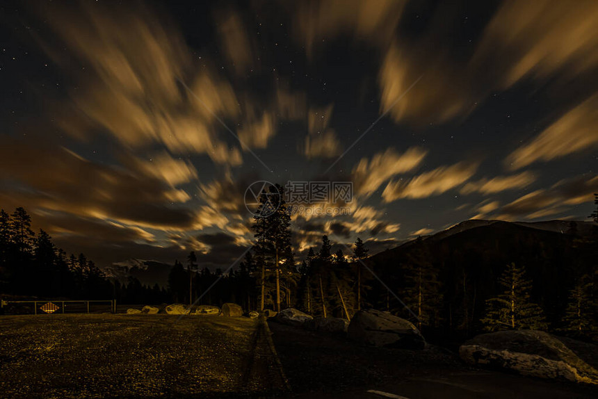 黑暗的山峰其背景是夜空有星和云彩图片