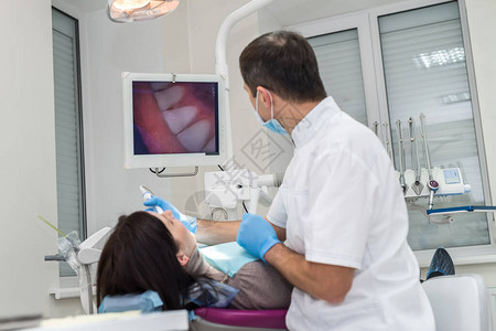 牙科医生检查病人牙齿用摄影机进图片