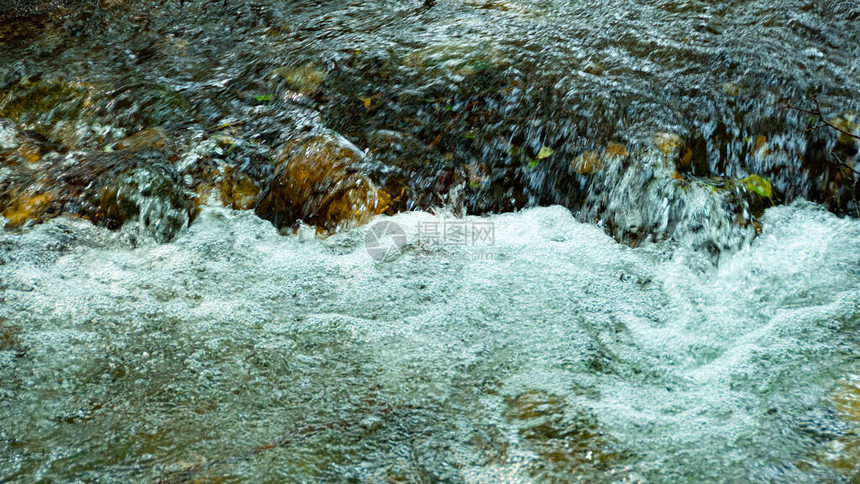岩床的溪流岩石之间的快山河水在洋流图片