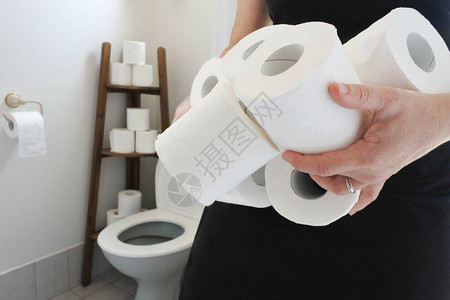 女人带着许多卫生纸卷到厕所过度使用卫生和医疗健康概念复制空图片