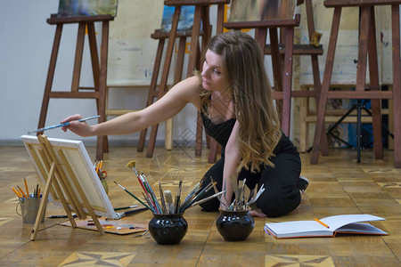 女艺术家坐在艺术工作室的地图片