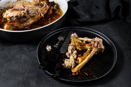 一盘鸡骨头和一个烤盘里的鸡骨架晚餐的剩菜黑色图片