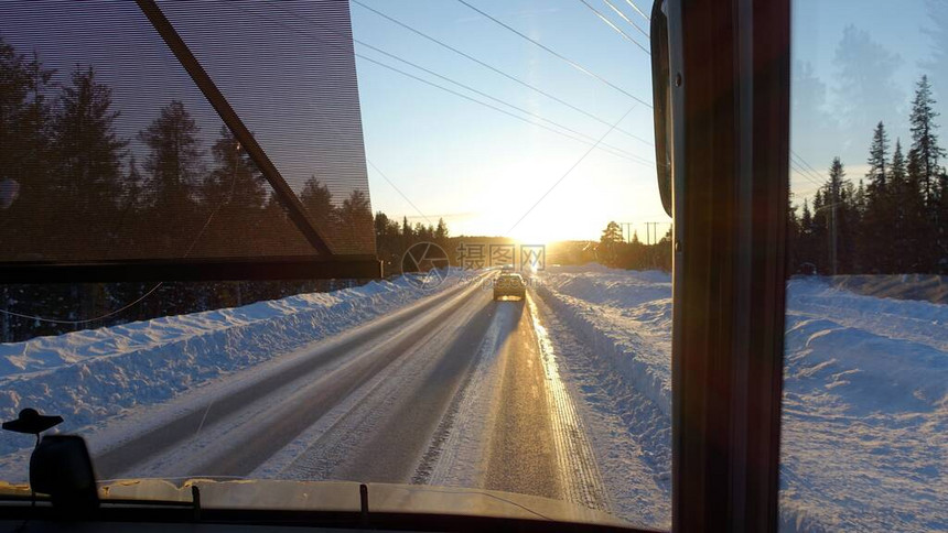 巴士日落时在瑞典北部的雪地路上看到公共图片