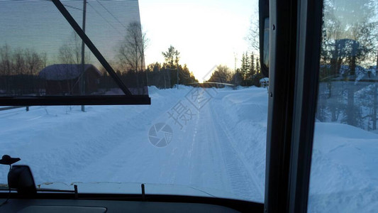 巴士日落时在瑞典北部的雪地路上看到公共图片