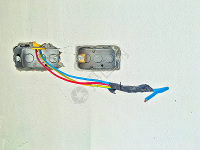 白色混凝土背景上带电线的电源插座或电源插图片