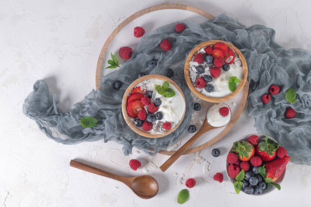 为健康早餐提供酸奶和浆果一碗加草莓蓝莓和草图片