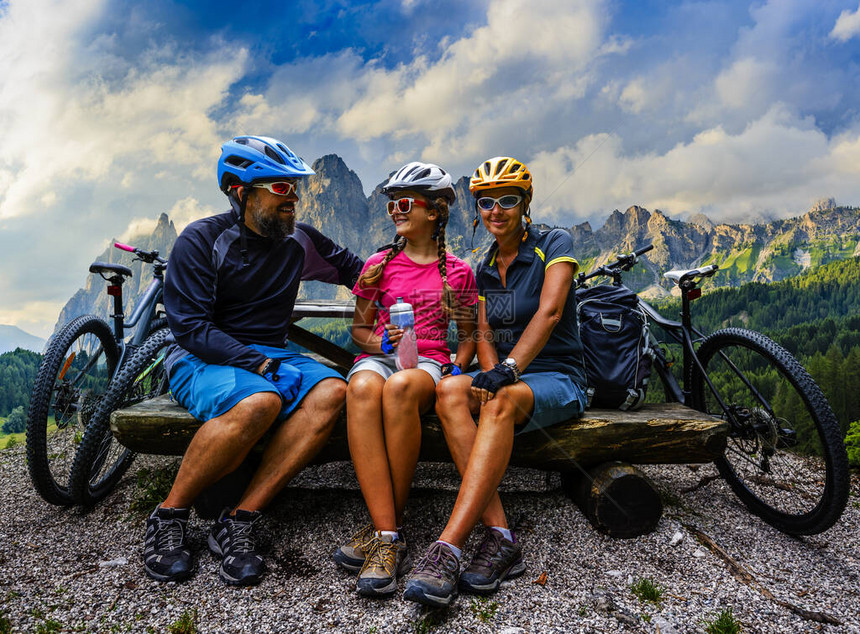 骑自行车的家庭在多洛米蒂山脉景观中骑自行车情侣骑自行车MTB耐力赛道图片
