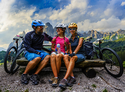 骑自行车的家庭在多洛米蒂山脉景观中骑自行车情侣骑自行车MTB耐力赛道图片