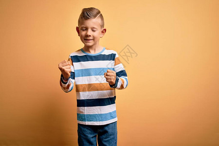 蓝眼睛的小天主教小男孩穿着多彩的条纹衬衫图片