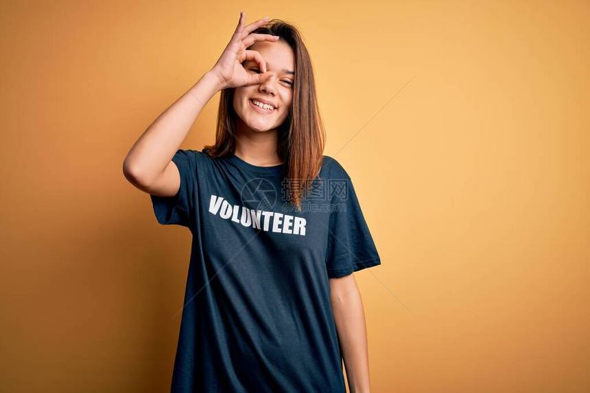 年轻漂亮的黑发女孩做志愿者穿着t恤与志愿者信息字做ok手势用手微笑图片