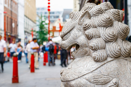 一个守护狮子的雕像和拥挤不堪的伦敦唐人图片
