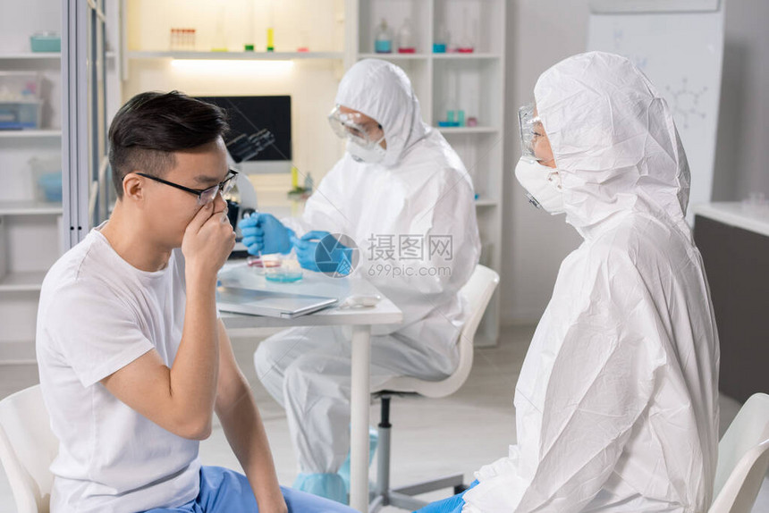 生物危害西装和呼吸口罩专家与孤立研究室的冠状人交谈图片