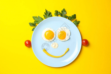 笑脸由盘子和炒鸡蛋制作在黄色背图片