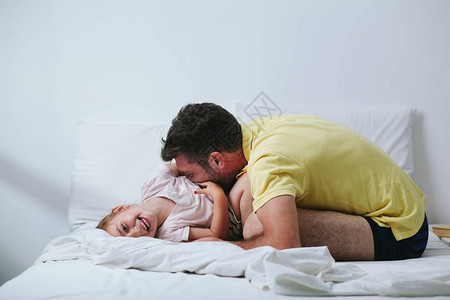 父亲和女儿在床上玩耍图片