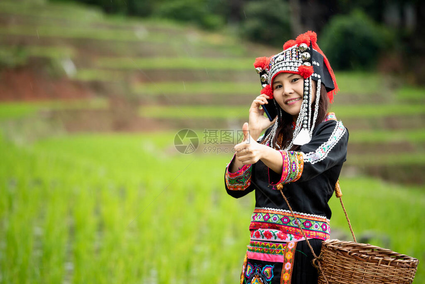 在稻田行走时用手机和拇指呼唤亚洲赫图片