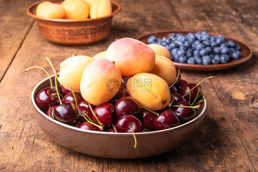 美味成熟的杏子浆果樱桃和蓝莓在生锈的图片