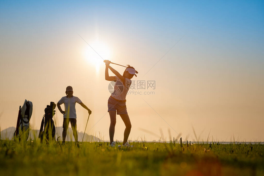 情侣恋人在球场上一起打高尔夫球图片