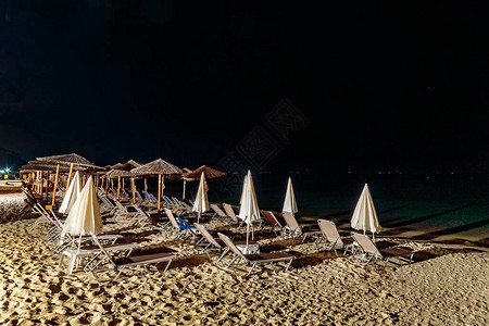 晚上在海上的遮阳伞和沙滩椅图片