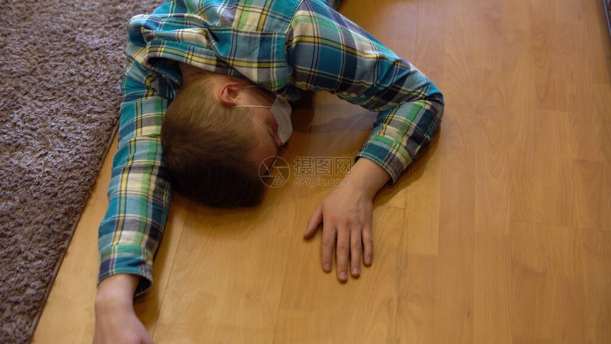一名戴着口罩的男子躺在失去知觉的地板上图片