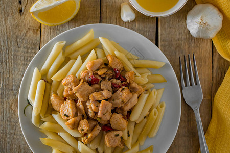 地中海食物面食和美味的鸡肉在黄纸巾图片