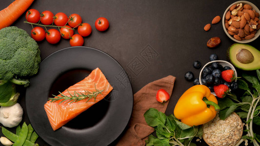 健康食品含鲑鱼水果蔬菜种子和黑桌上复制空图片