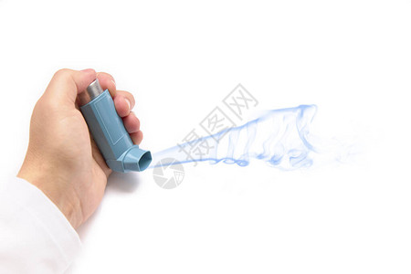 白色背景中带有哮喘吸入器的手健康概念图片
