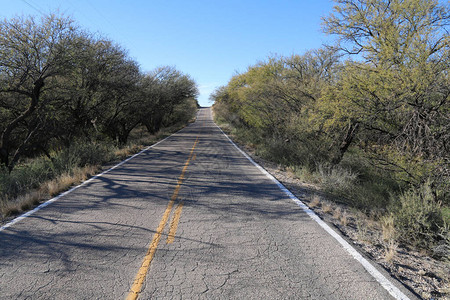一条通往地平线的破旧两车道沙漠公路图片