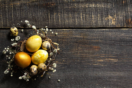复活节彩蛋背景巢中的金色复活节彩蛋和木桌上的复活节装饰顶视图平躺背图片