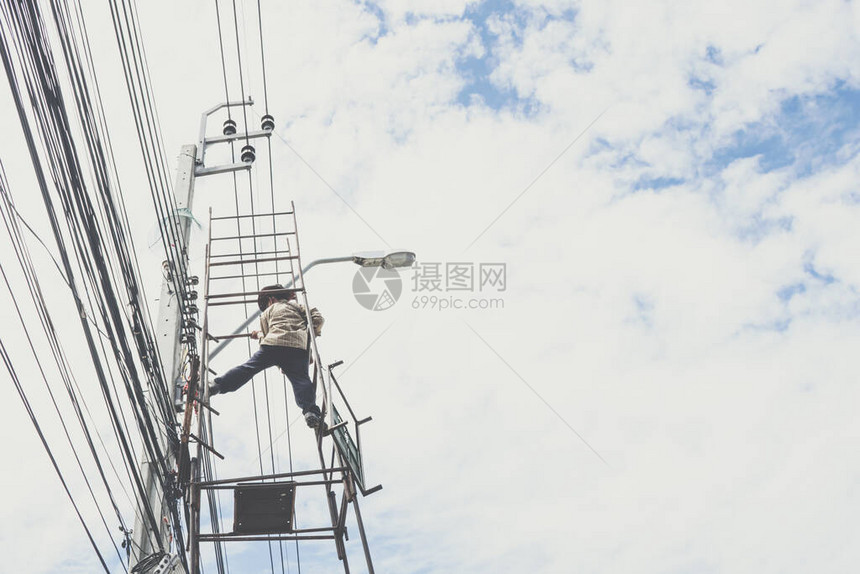 电工杂工或人在泰国曼谷小卡车上用脚手架在高杆上安装图片