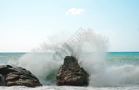 海浪正在猛烈地冲击着岩石产生巨大的喷洒地中海的洋图片