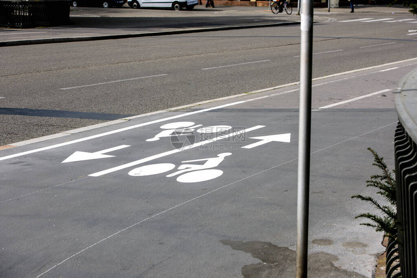 灰色沥青上的自行车标志显示两个循环和方向箭头图片