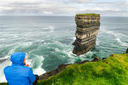 穿着蓝色夹克的游客正在寻找北爱尔兰的唐帕特里克头探索旅游目图片