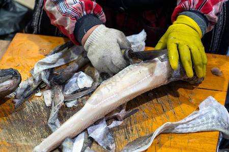海产食品市场的夏普刀清洗鱼购物和切图片