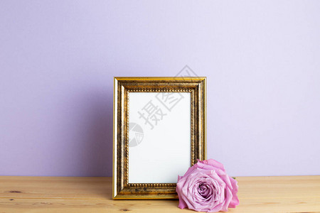 木制桌边有紫玫瑰和紫色面画背景的相片框周年纪念概花卉安图片