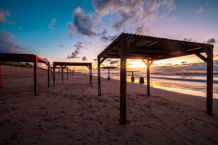 日落在沙滩上有遮阳雨伞晚上图片