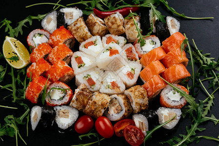 好吃的寿司卷和三文鱼虾和熏黑盘上图片